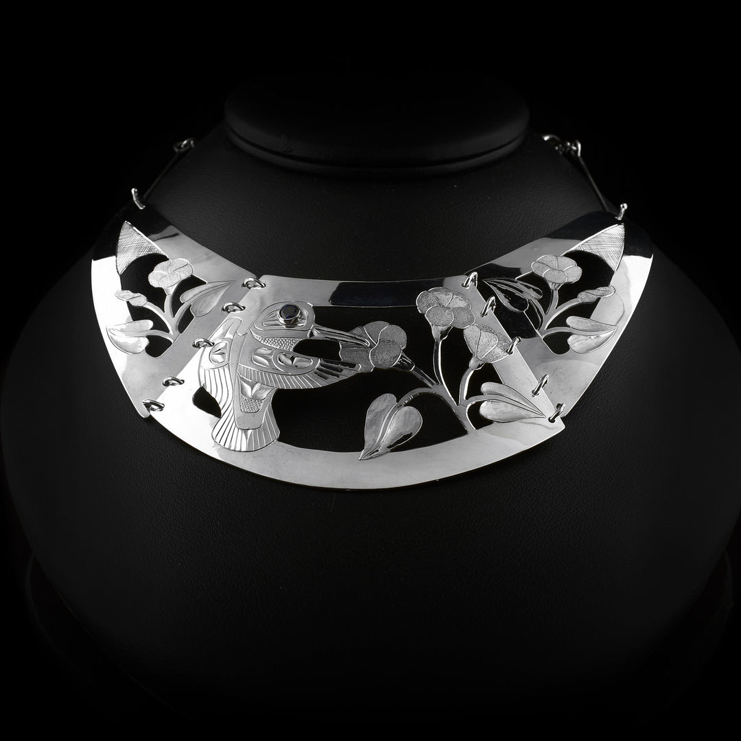 Handcrafted three-piece sterling silver necklace by Tlingit artist Fred Myra, featuring a hummingbird design with a sapphire set in the eye.