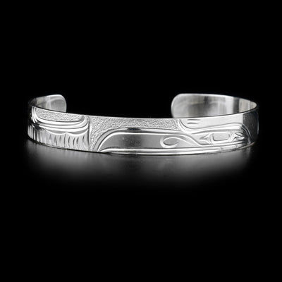 Sterling silver cuff bracelet with raven design. Textured background. 0.38” wide. Hand-carved by Kwakwaka’wakw artist Cristiano Bruno.