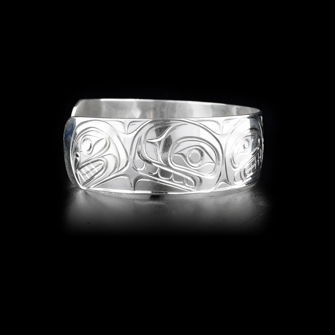 Right side of sterling silver cuff bracelet featuring orca pod.