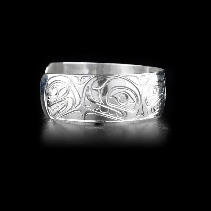 Right side of sterling silver cuff bracelet featuring orca pod.