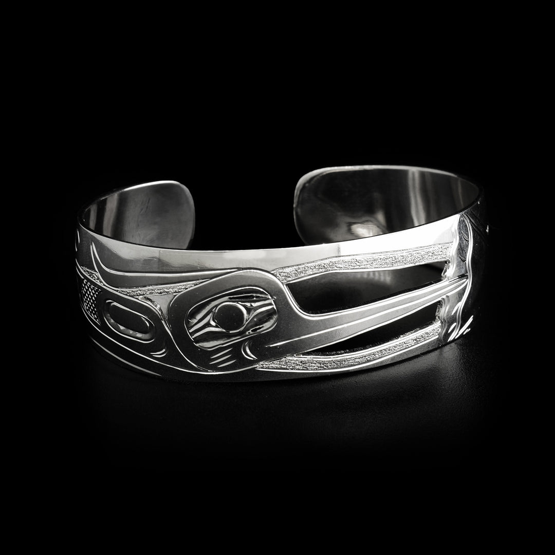 Front of bracelet depicts side-view of hummingbird’s head with cut out parts behind. Right side depicts side-view of hummingbird’s body.