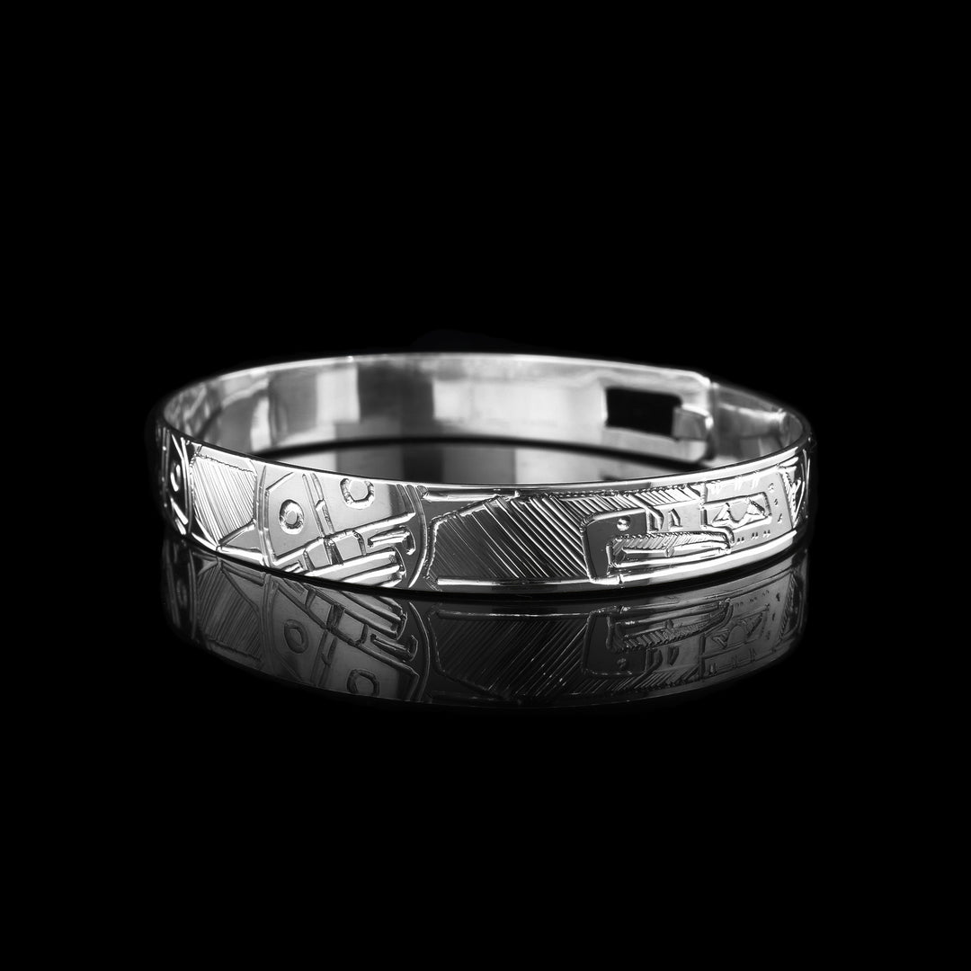 This sterling silver bangle braclete has hand carvings of the thunderbird and the sun legend. 