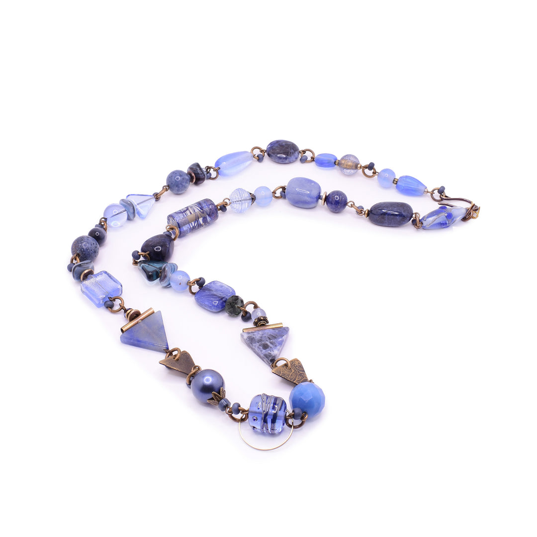 Tofino Blue Beaded Necklace made with multiple types of materials like blue quartz, brass, lampwork glass, and Swarovski crystals.