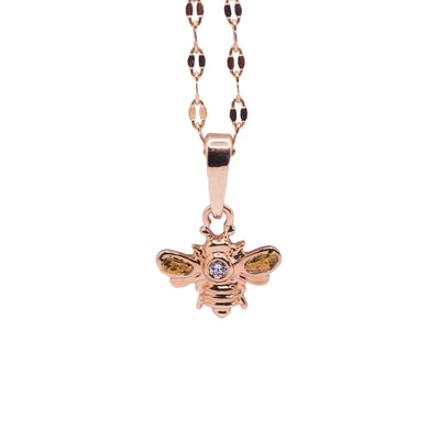 This gold bee pendant is made up of 10K gold and is in the shaped of a bee with its wings outstretched. There are 22K gold nuggets held in the wings of the bee and a diamond embedded in the center of it.
