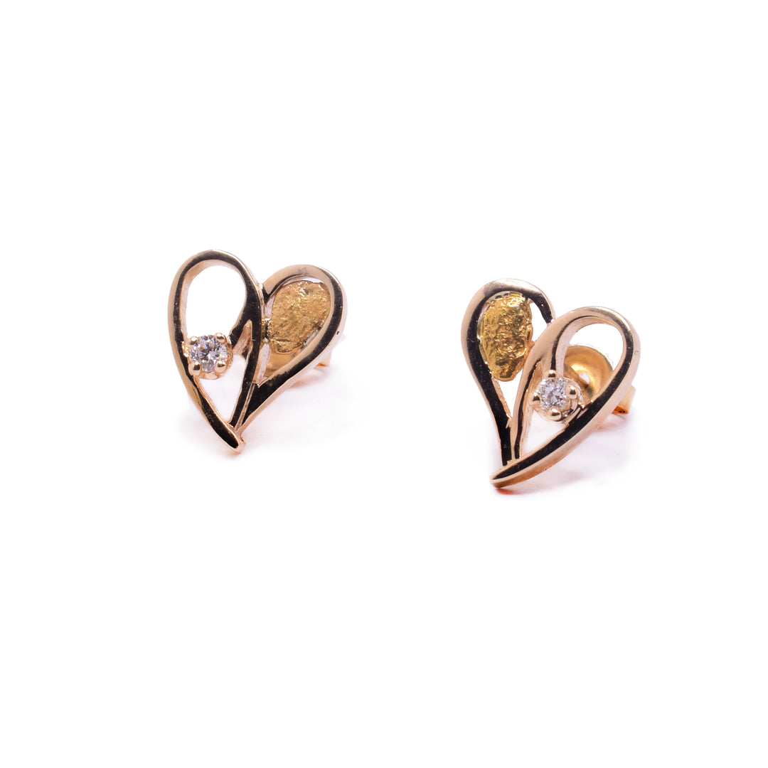 These heart shaped diamond stud earrings are made from 10K gold, cutout hearts that have a 22K gold nugget on one side and a 3 - point diamond on the other.
