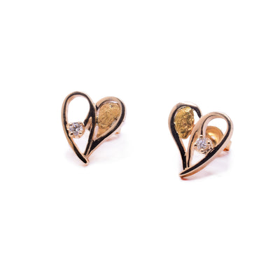 These heart shaped diamond stud earrings are made from 10K gold, cutout hearts that have a 22K gold nugget on one side and a 3 - point diamond on the other.