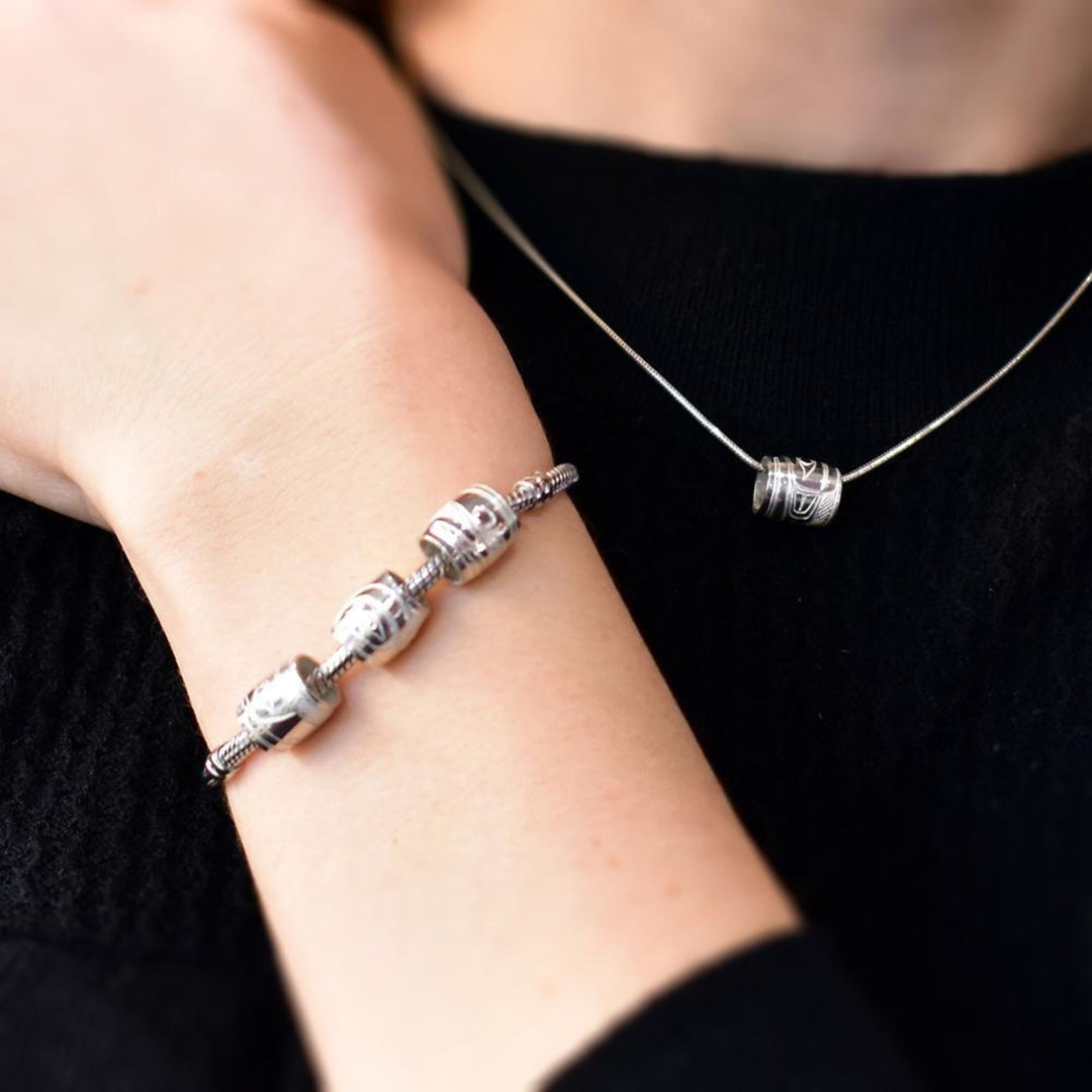 Secondary photo shows silver beads on a necklace and charm bracelet.