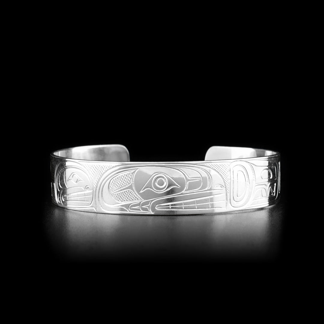 This sterling silver bangle bracelet has a single band with a gap in the back with two depictions of the Orca carved into the surface of the band.