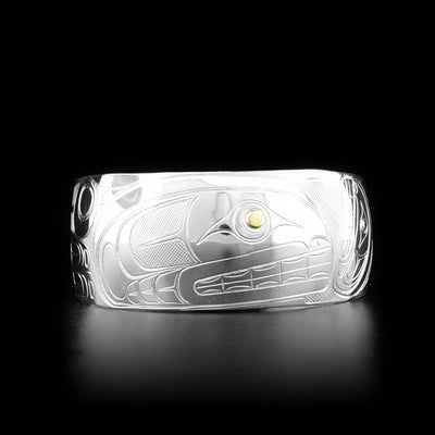 This silver and gold cuff bracelet is made from sterling silver and 14K gold and has a wide band that tapers slightly. There are two depictions of the Orca carved into the surface of the band and the eyes of the Orcas' are made from 14K gold.