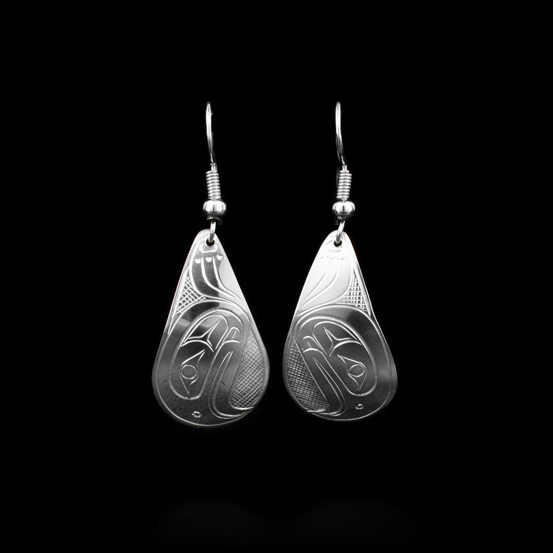 These stelring silver dangle earrings have teardrop shaped hangs with depictions of the Eagle carved into the surface of them.