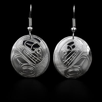 These sterling silver dangle earrings have oval shaped hangs and there are depictions of the Orca carved into the surface of them.