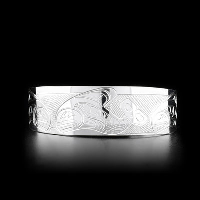 This Orca bracelet is made from sterling silver and has a wide band with a gap in the back. There are depictions of an Orca pod carved across the surface of the band.