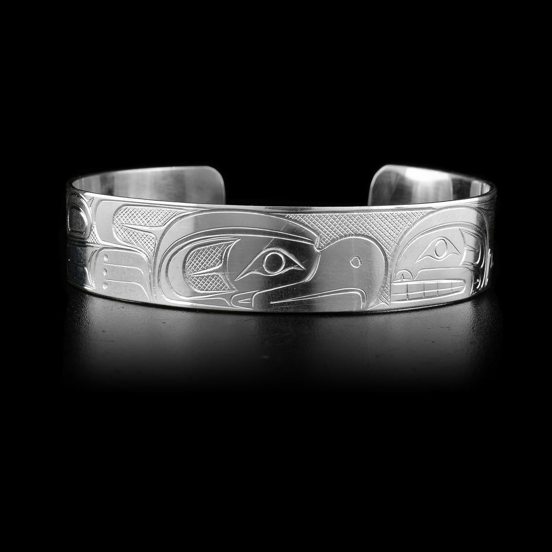 This sterling silver cuff bracelet has a depiction of the Orca and the Thunderbird carved into the surface of the band. The legends are depicted facing each other.