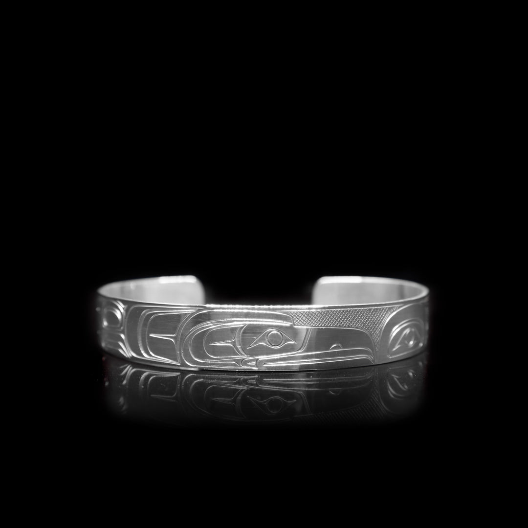 This sterling silver cuff bracelet has a depiction of the Raven carved into the surface of it.