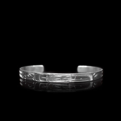 This sterling silver cuff bracelet has a thin band with depictions of the Eagle and the Raven carved into it.