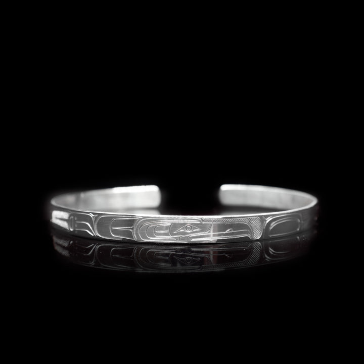 This thin sterling silver cuff bracelet has a depiction of the Raven carved into the surface of the band.