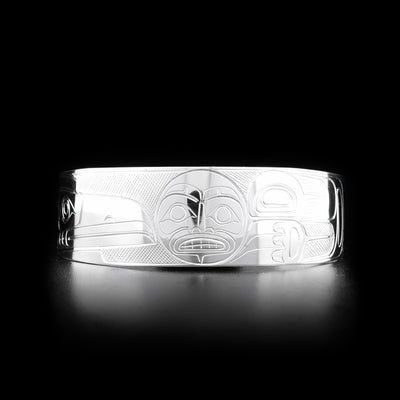 This Raven and Moon bracelet cuff is made from sterling silver and has a wide band with a gap in the back. There are depictions of the Raven and the Moon carved into the surface of the band.
