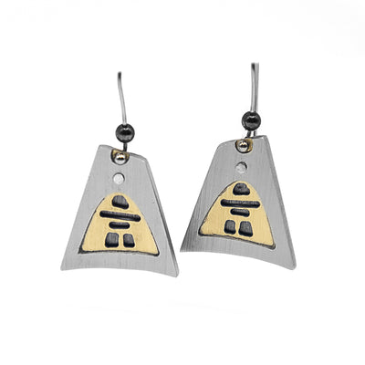 Brushed and anodized aluminum earrings. Each earring is a large, triangular silver-coloured frame with a grey inukshuk inside. Background of inukshuk is gold-coloured. Hooks are stainless steel.