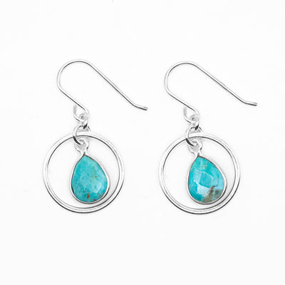 Dangle hoop earrings with flat, faceted turquoise teardrops dangling in hoops. Metal is sterling silver.