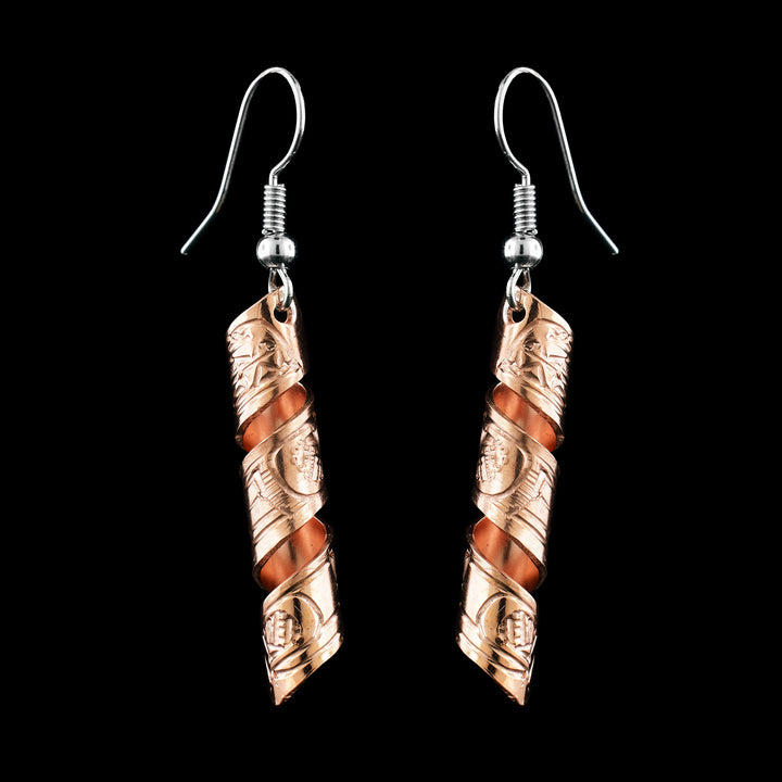 The earrings are made with a copper band that has been molded into a swirl. On the earrings is a hand-carved depiction on the Orca legend.
