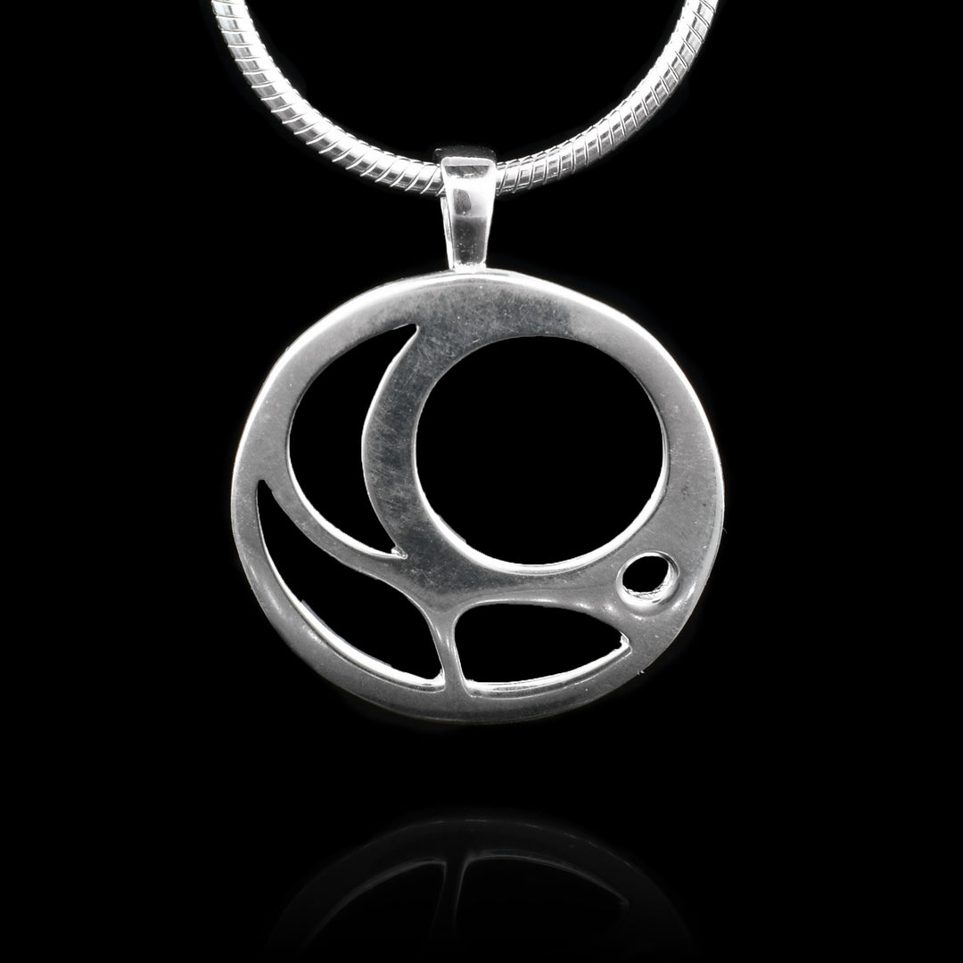 This sterling silver pendant is circle shaped and there are multiple cutouts that depict an egg from the Salmon.
