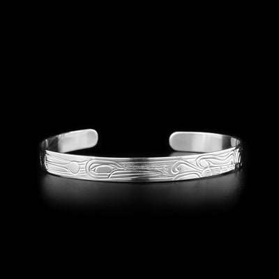 This Hummingbird bracelet has a thin band and is a cuff bracelet. There are depictions of the Hummingbird and a butterfly carved into the surface of the band.