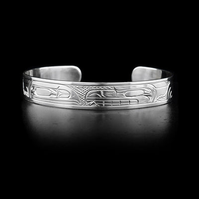 This sterling silver band has depictions of the Raven and the Bear carved into it. Their heads meet at the top of the bracelet.