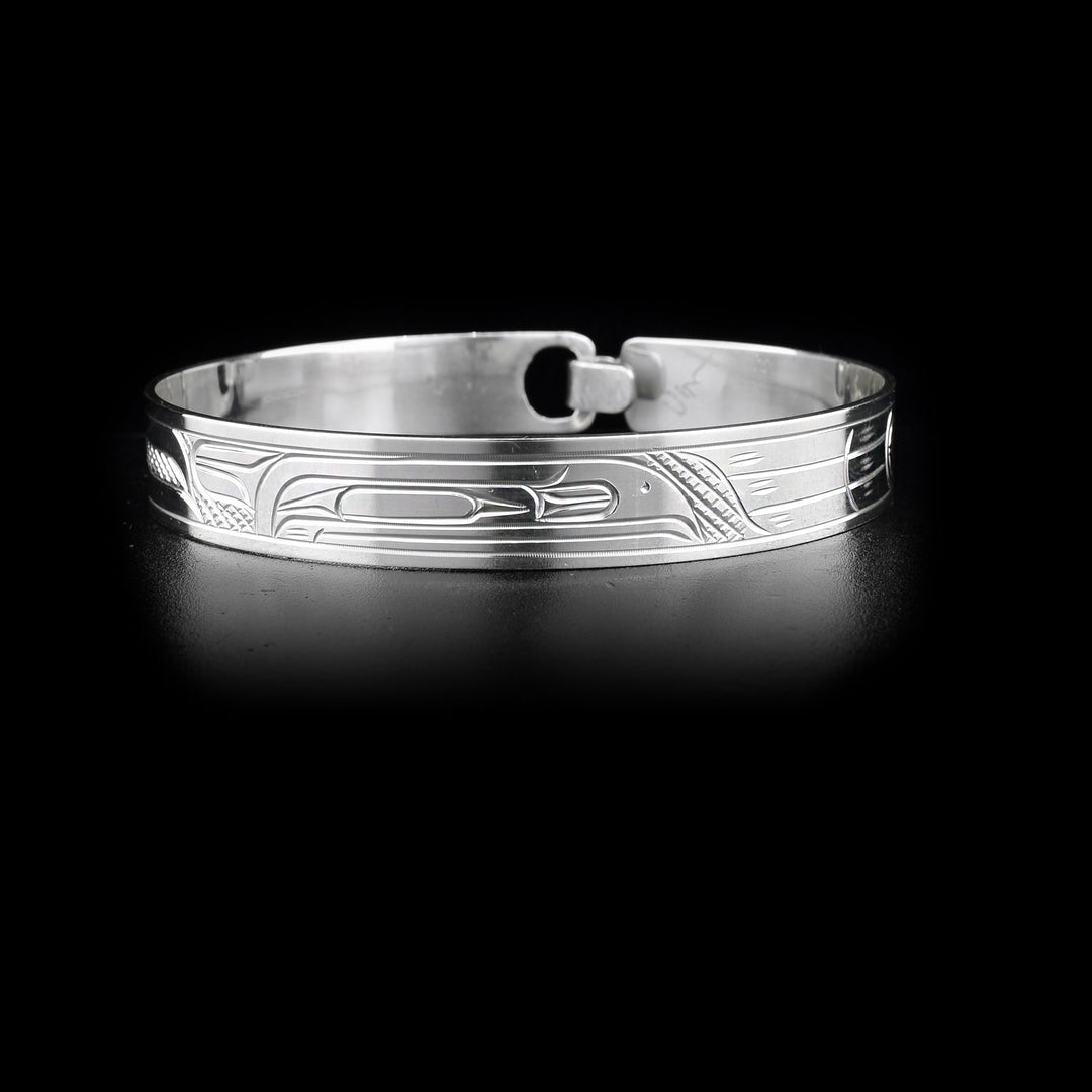 This sterling silver bangle has a depiction of the Raven carved around it. There is a built in clasp in the back.
