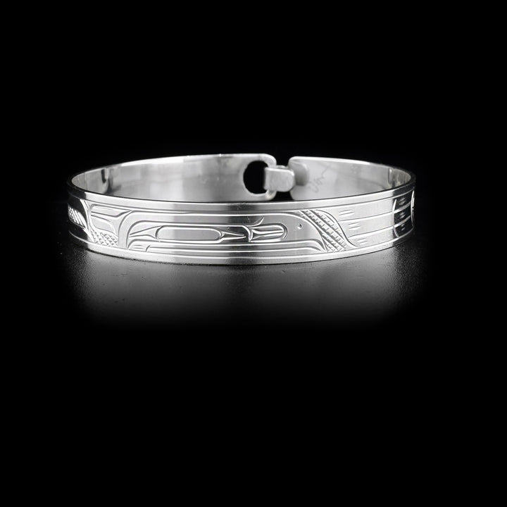 This sterling silver bangle has a depiction of the Raven carved around it. There is a built in clasp in the back.