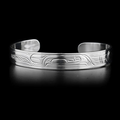 This sterling silver cuff bracelet is thin and has a depiction of the Raven carved into it.