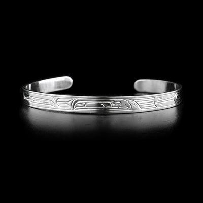 This sterling silver cuff bracelet is thin and small. It has a depiction of the Raven carved into it. 