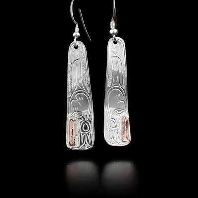 Each sterling silver earring is long and tapered and features an orca. Orca has 14K gold head. Earring is wavy. By Kwakwaka’wakw artist Victoria Harper.