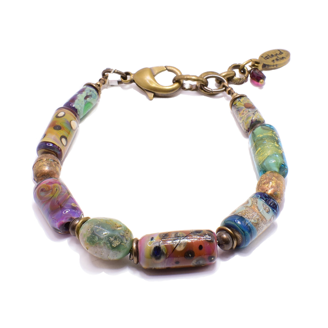 This unique glass bead bracelet is made from brass and lampworked glass beads. The beads are colorful and there are unique and colorful patterns on each of the beads.
