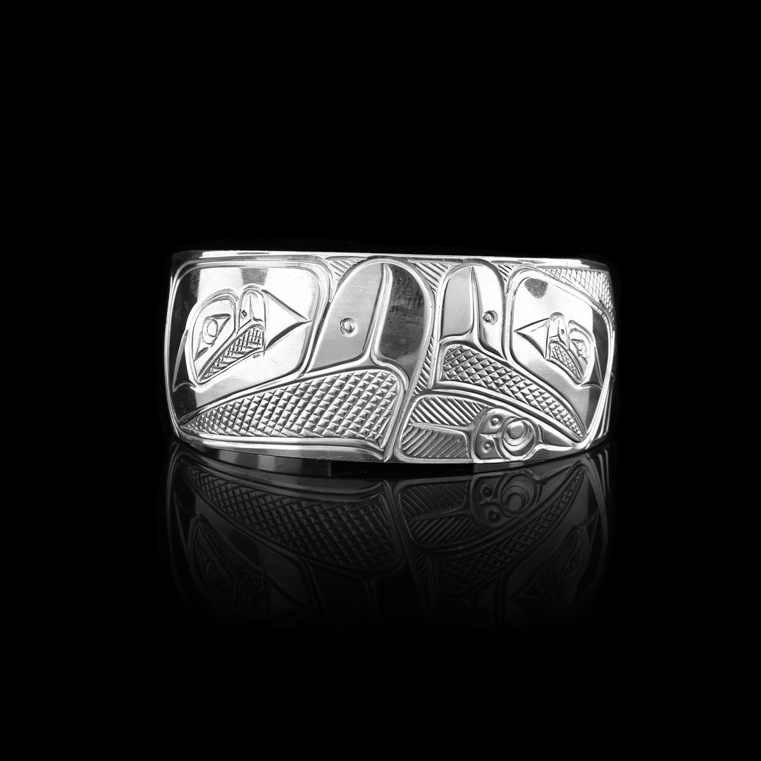 A sterling silver Eagle bracelet that has two Eagles hand carved in the middle. They are facing each other.
