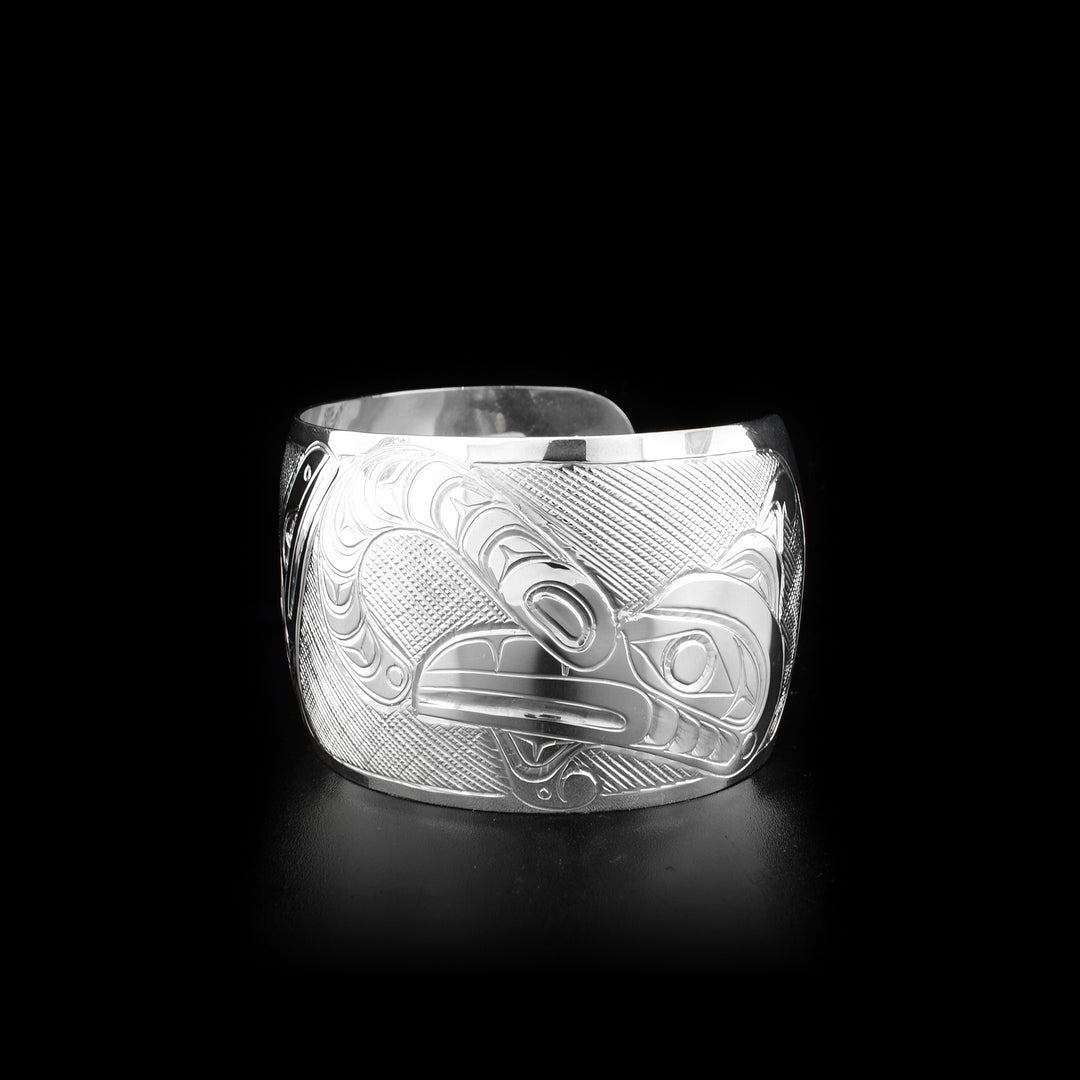 Sterling silver 1.5” wide cuff bracelet depicting scene of two thunderbirds feeding their baby.