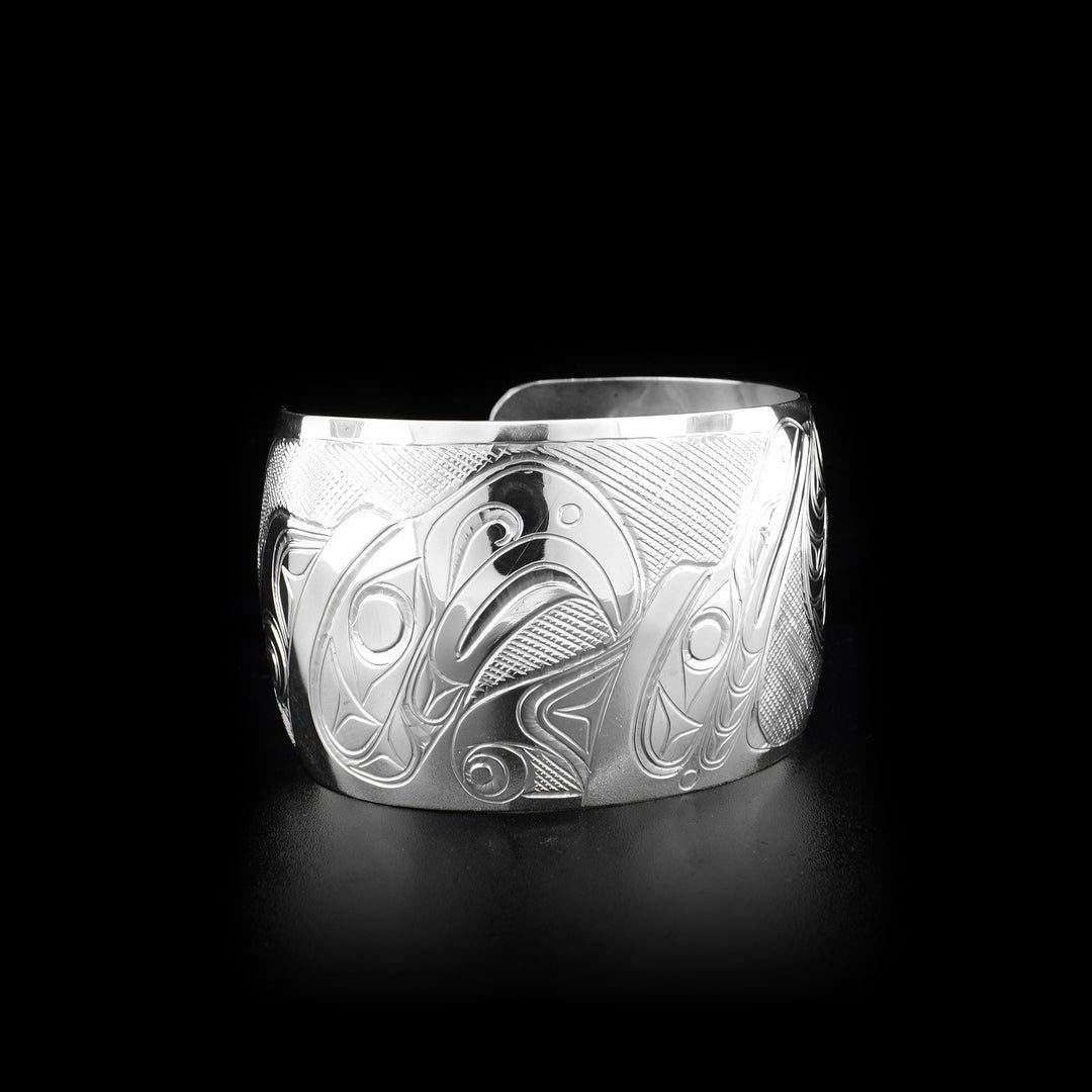Sterling silver 1.5” wide cuff bracelet depicting scene of two thunderbirds feeding their baby.