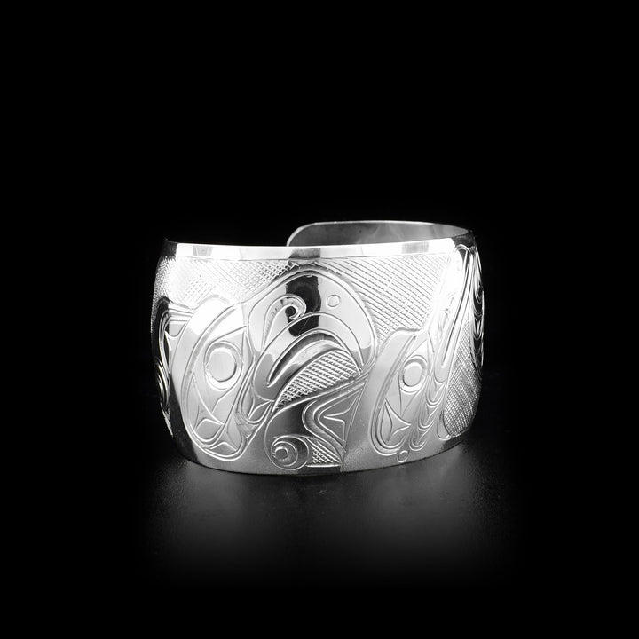 Sterling silver 1.5” wide cuff bracelet depicting scene of two thunderbirds feeding their baby.