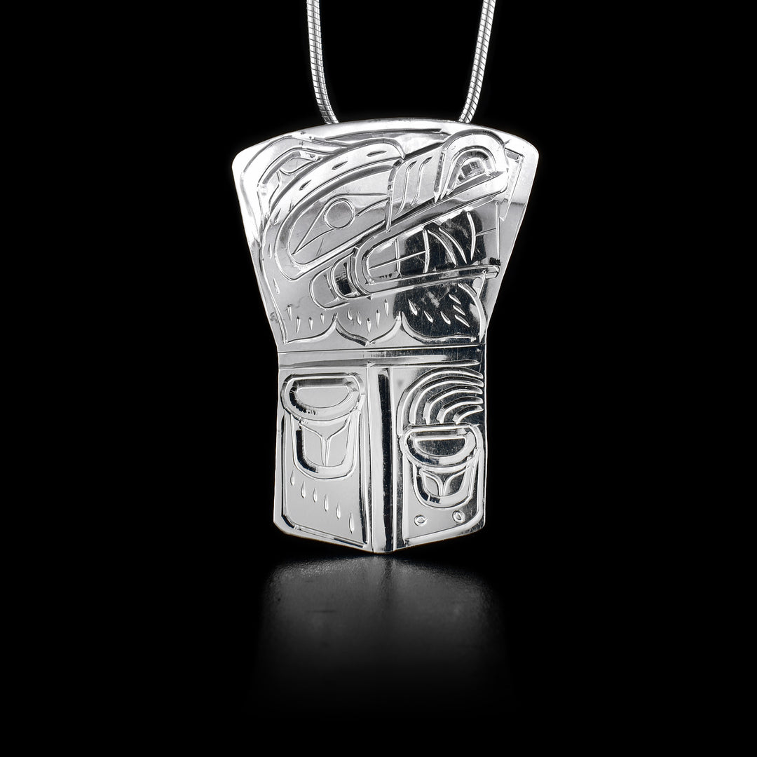 This strong Bear pendant has been made using sterling silver and is shaped like a large rectangle shield that tapers out at the top. There is a depiction of the Bear carved into the surface of the piece.