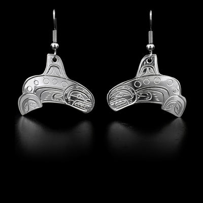 These sterling silver dangle earrings have hangs that are shaped like and has carvings that depict the Orca.