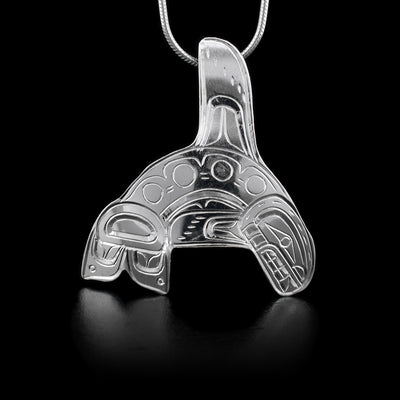 This sterling silver pendant is shaped like the Orca and has engravings depicting the Orca.