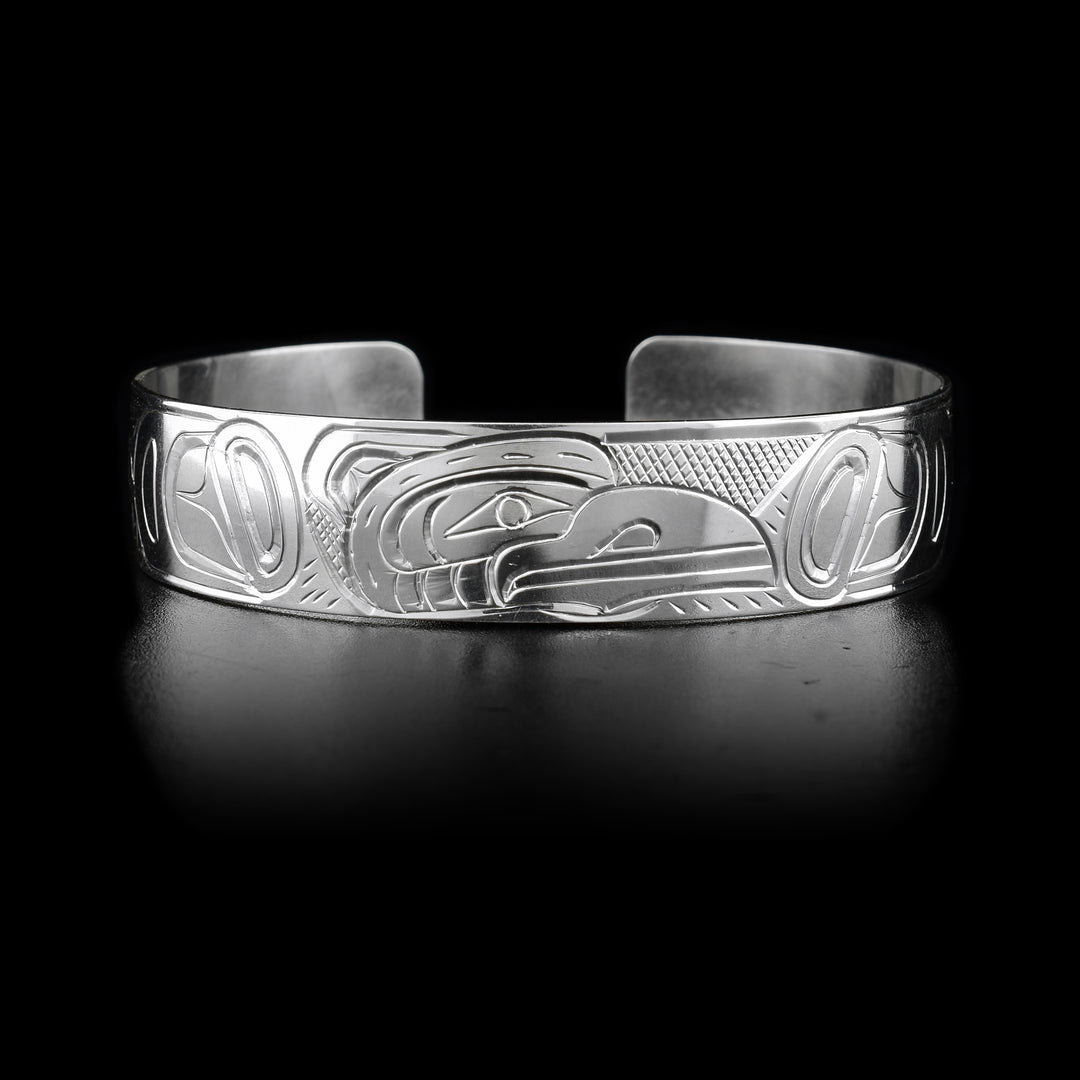 This Raven bracelet has a single, thin and sterling silver band with a gap in the back. There is a depiction of the Raven carved into the surface of the band.