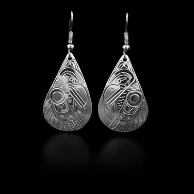 These sterling silver dangle earrings have large teardrop shaped hangs with carvings that depict the Raven.