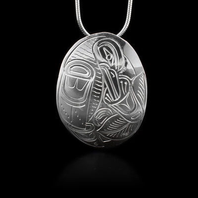 This sterling silver pendant is oval shaped and is carved to depict the Raven and a flower