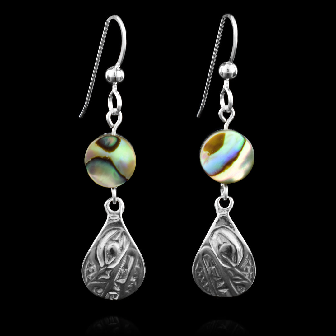 These teardrop earrings have a beautifully carved wolf design in sterling silver. Each teardrop is topped with a vibrant abalone shell bead, whose natural hues of green, blue, and violet add a dynamic contrast to the silver below. Suspended from sleek French hooks.