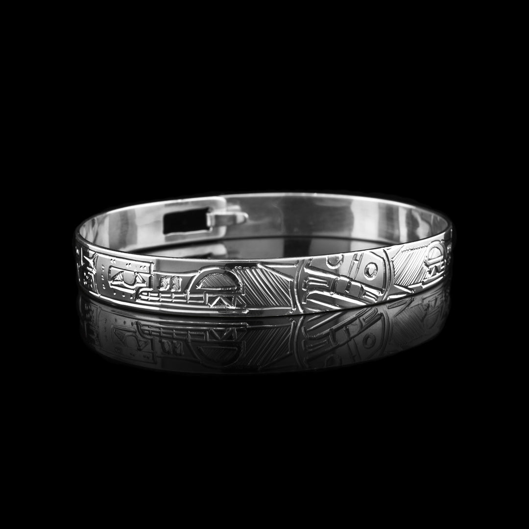 This silver bangle bracelet has a depiction of the Wolf and a depiction of the Sun. The Wolves are depicted facing the Sun at the top of the band.
