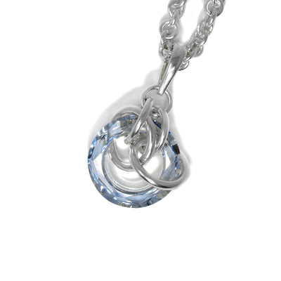 Blue shade Swarovski crystal ring with interconnected sterling silver rings woven around and through it. Pendant measures 1.5” x 0.7” including bail.