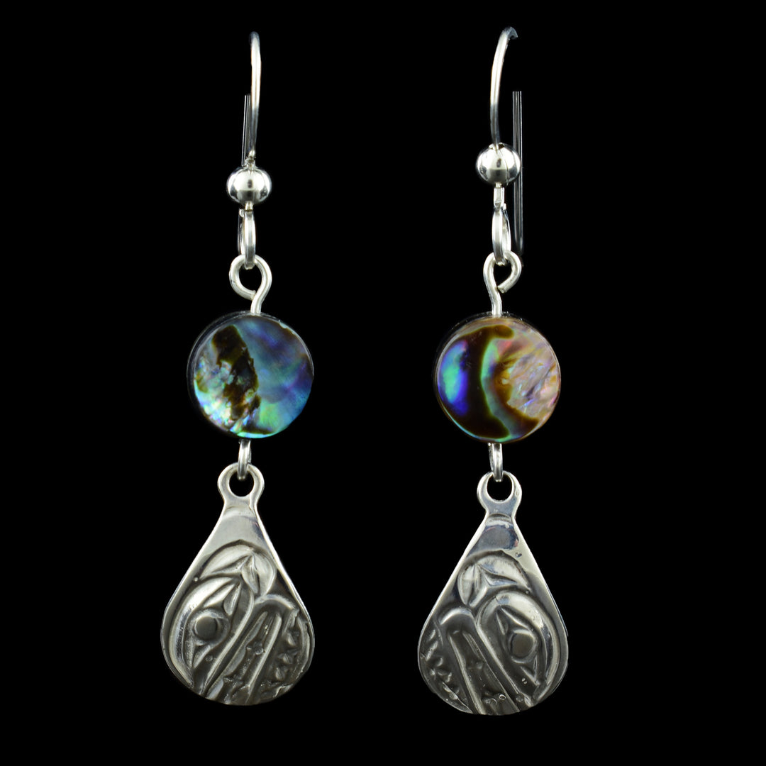 These elegant teardrop orca earrings feature a finely detailed Orca design carved in sterling silver. Above each teardrop hangs a vibrant abalone shell bead, shimmering colours of blue, green, and violet that catch the light beautifully. Suspended from simple French hooks.