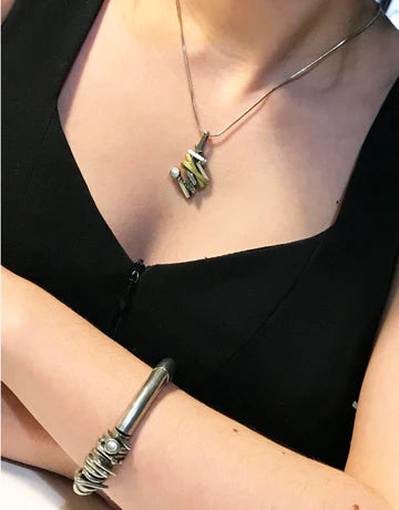 This photo shows the pendant on the neck of the model. You can see the torso of the model.