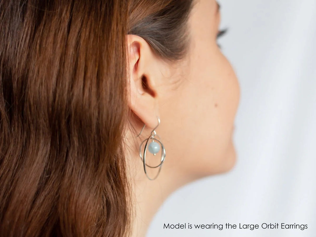 A model wears the piece and it is seen from the back at a side profile.