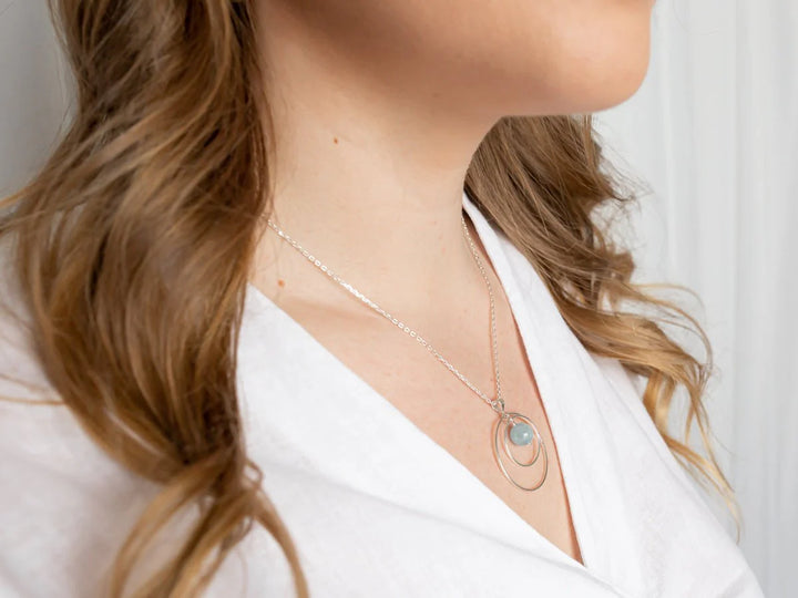 This photo is a close up of a model wearing the necklace. It lays flat against her chest.